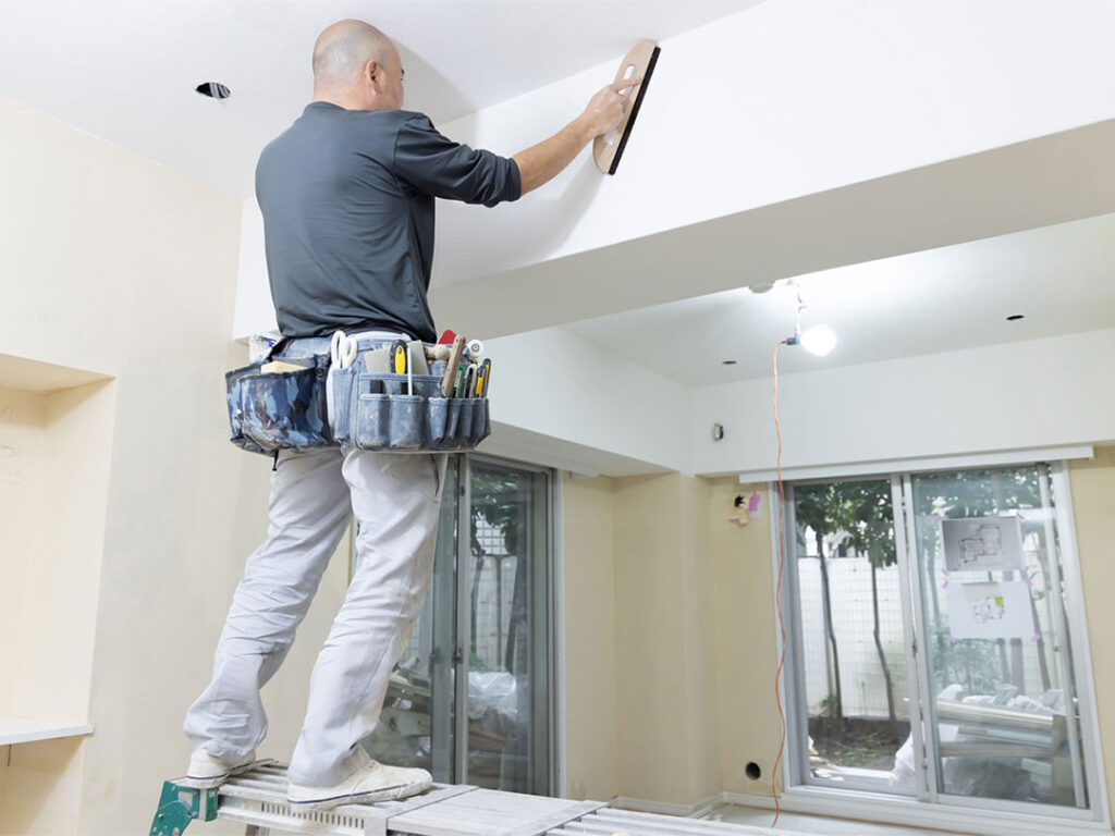 リフォーム現場で天井を仕上げる職人