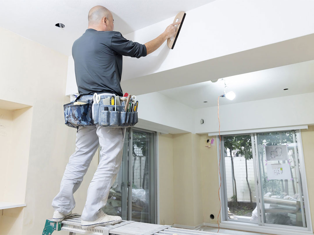 リフォーム現場で天井を仕上げる職人